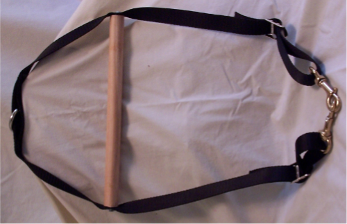 Wooden handle with black straps on fabric.